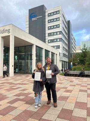 2022 10 28 david grimm lucy challoner David Grimm (right) and Lucy Challoner (left) who are leading the @swstudentsunite campaign hold the jointly signed letter on 28 October 2022. The letter calls for better bursaries for Scottish social work students.