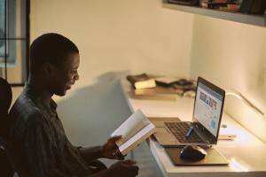 Man sits at computer studying - emmanuel-ikwuegbu Man sits at computer studying - emmanuel-ikwuegbu