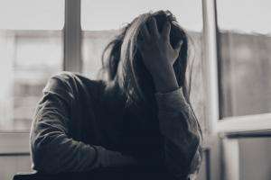 pars sahin jq00t2qsnwo unsplash woman holds head in hands