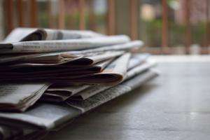 pexels brotin biswas 518543 A stack of newspapers on an office table