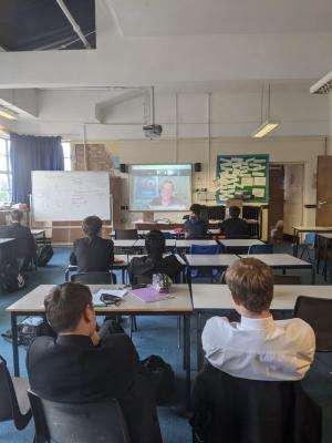 shout out uk whatsapp image 2021 07 13 at 14.39.19 Year 10 students sit at their desks in a classroom. They are looking at a projector screen showing the Zoom call with SWU General Secretary John McGowan for the Shout Out UK workshop on social work and trade unions.